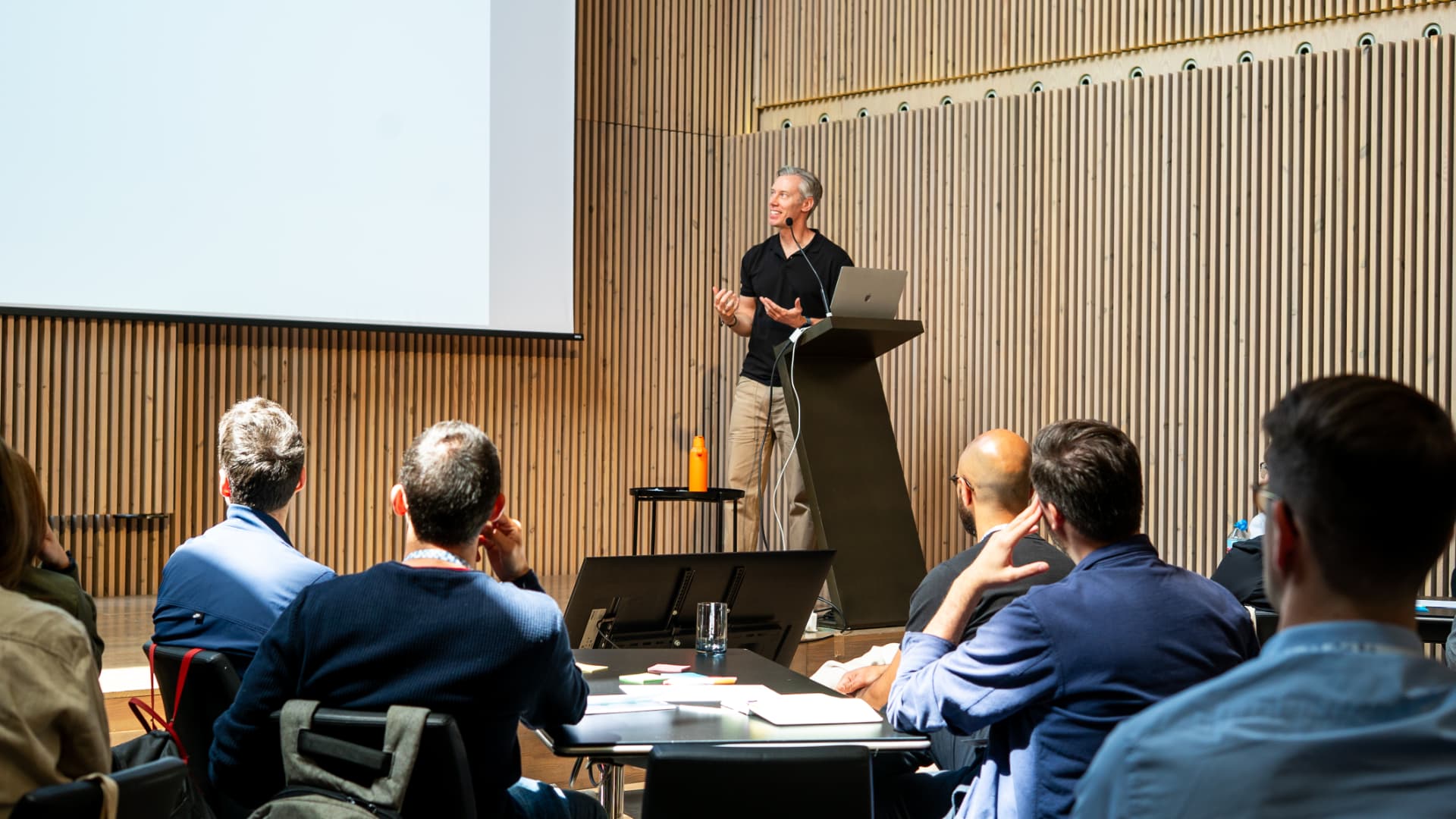 Martyn speaking at a podium to a seated audience in a conference hall